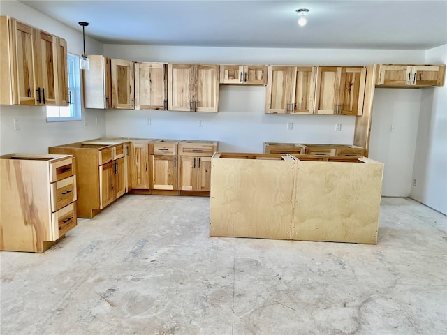 kitchen featuring light brown cabinets and pendant lighting