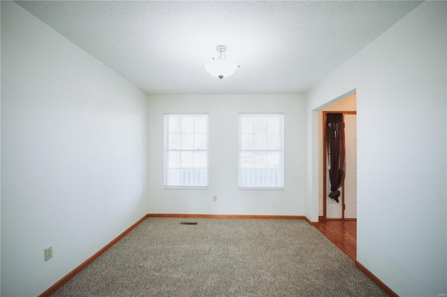 empty room featuring carpet floors and a textured ceiling