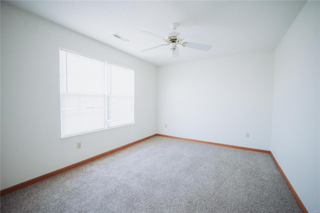 spare room featuring ceiling fan, plenty of natural light, and carpet flooring