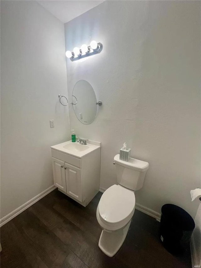 bathroom with vanity, toilet, and hardwood / wood-style floors