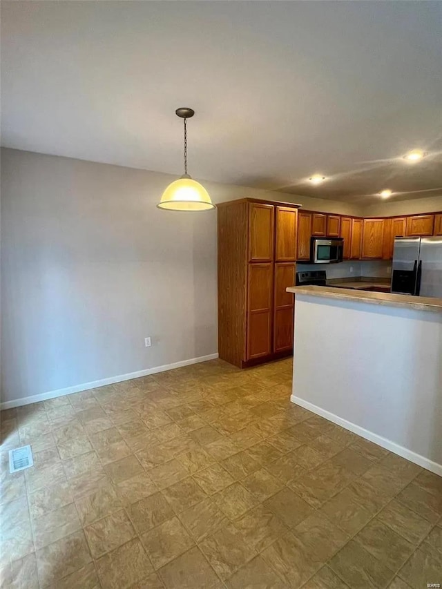 kitchen with appliances with stainless steel finishes and pendant lighting