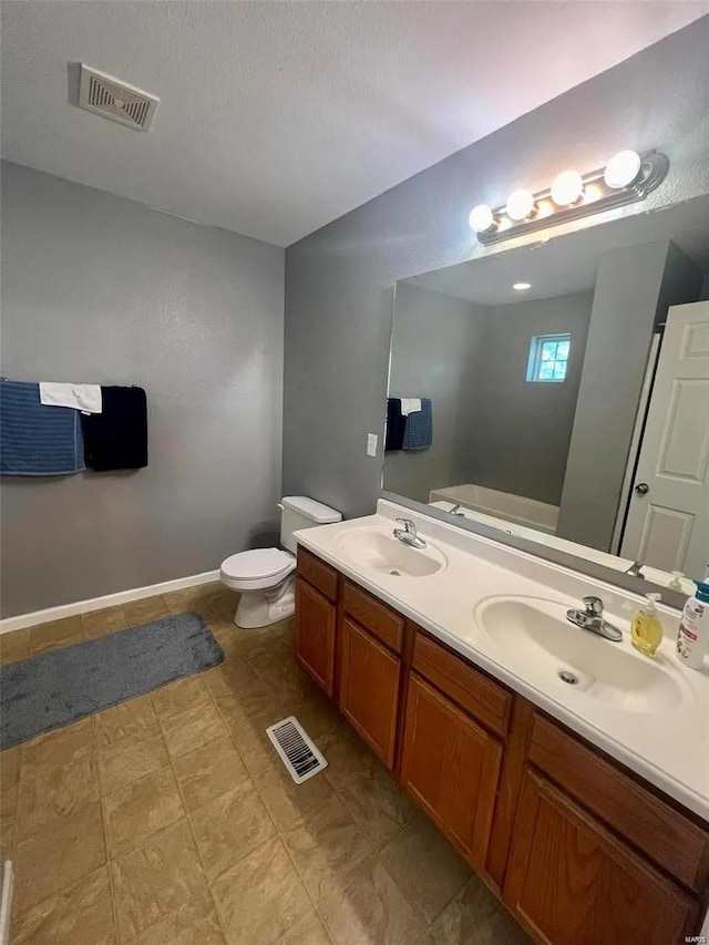 bathroom featuring toilet, a textured ceiling, and vanity