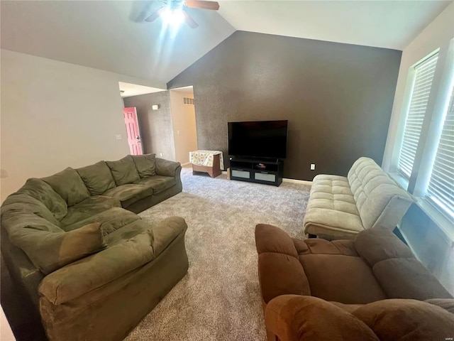 carpeted living room with ceiling fan, plenty of natural light, and vaulted ceiling