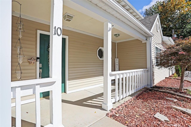 view of exterior entry featuring covered porch