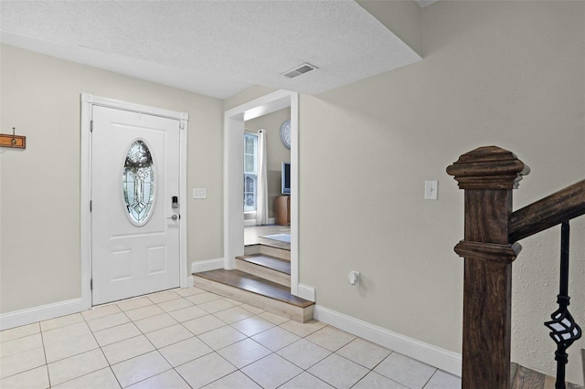 tiled entryway with a textured ceiling