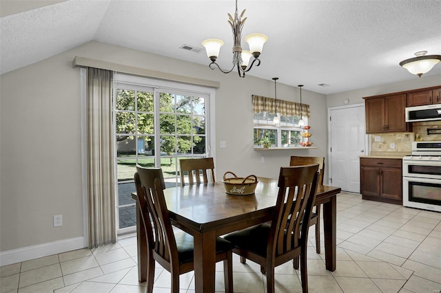 dining area with lofted ceiling, light tile patterned flooring, a notable chandelier, and a textured ceiling