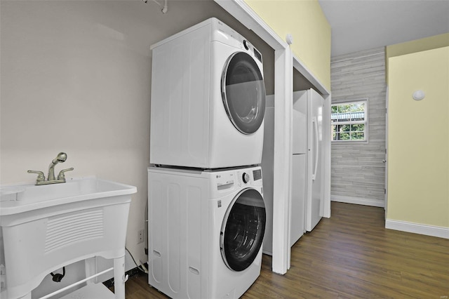 washroom featuring dark hardwood / wood-style floors and stacked washer / drying machine