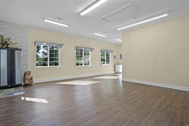 spare room featuring a textured ceiling and dark hardwood / wood-style flooring