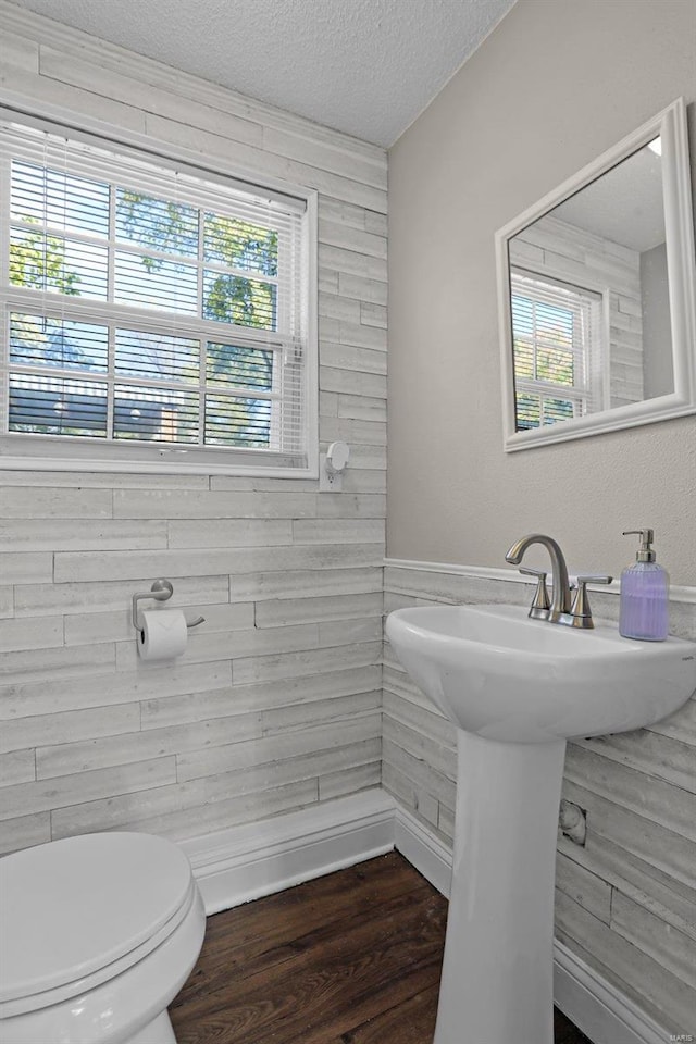 bathroom with sink, wood-type flooring, a textured ceiling, and toilet