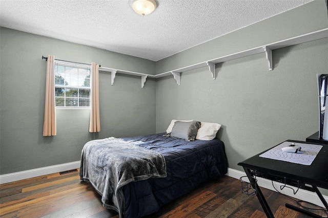 bedroom featuring a textured ceiling and dark wood-type flooring