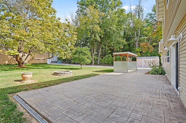 view of patio featuring a storage unit and an outdoor fire pit