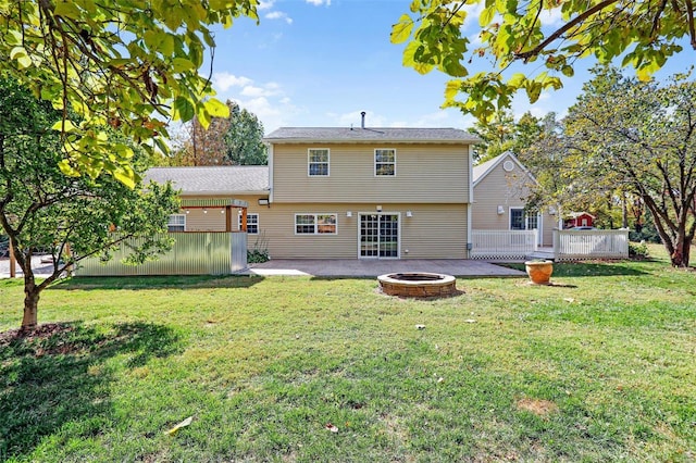 rear view of house featuring a patio area, a fire pit, a yard, and a deck