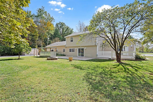 rear view of house featuring a yard, a storage shed, a fire pit, and a patio