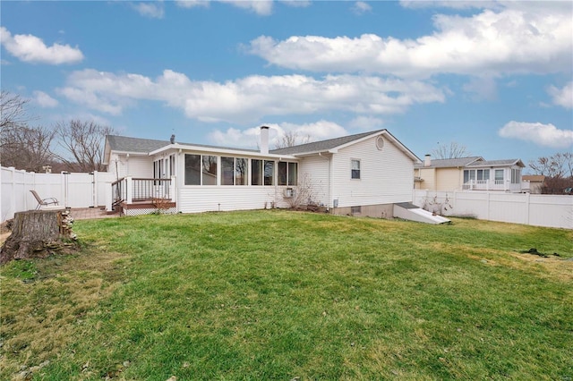 back of property with a sunroom and a lawn