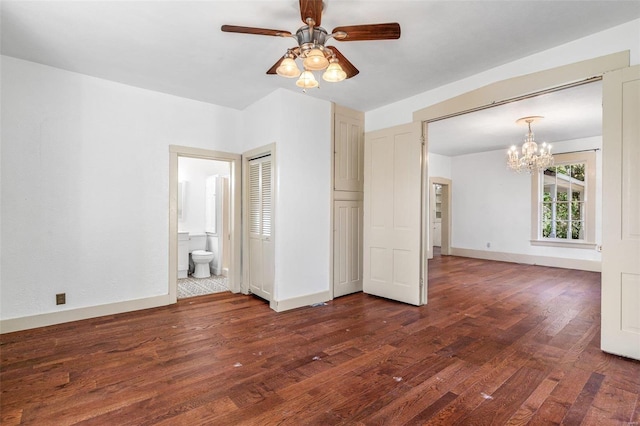 spare room featuring dark hardwood / wood-style floors and ceiling fan with notable chandelier