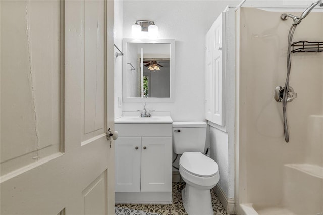 bathroom featuring toilet, ceiling fan, tile patterned floors, vanity, and a shower