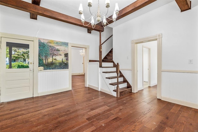 foyer entrance with a chandelier, beamed ceiling, and dark hardwood / wood-style flooring