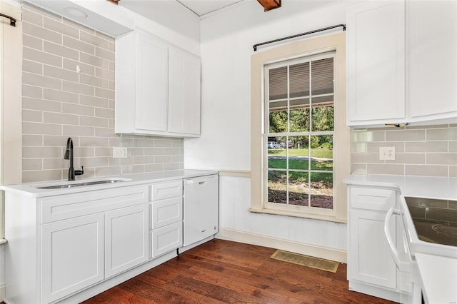 kitchen with white cabinets, tasteful backsplash, dark hardwood / wood-style floors, sink, and white appliances