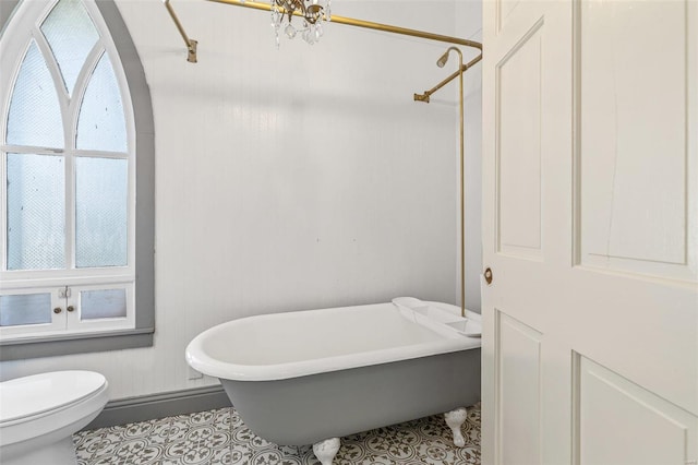 bathroom featuring toilet, a notable chandelier, tile patterned flooring, and plus walk in shower