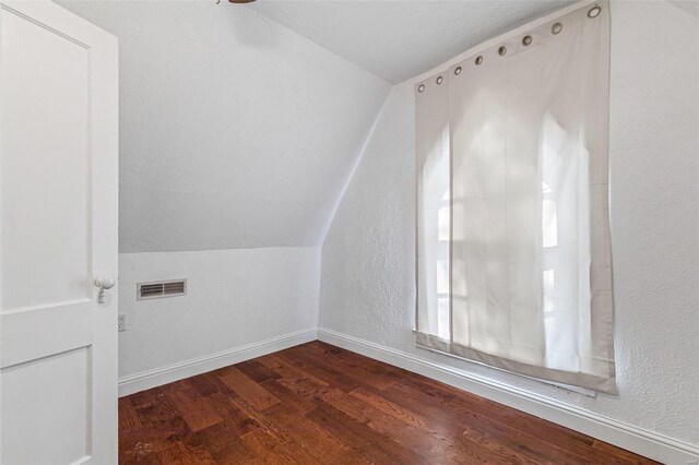 bonus room featuring lofted ceiling and dark hardwood / wood-style flooring