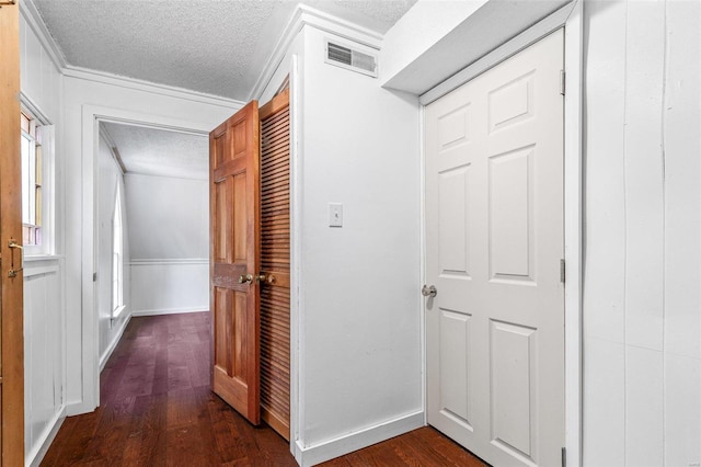 hallway featuring crown molding, a textured ceiling, and dark hardwood / wood-style flooring