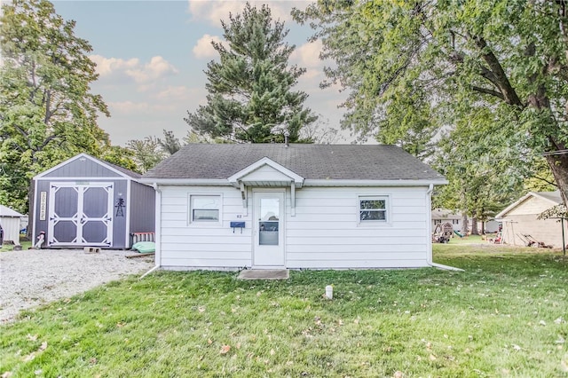 view of front of house featuring a storage unit and a front lawn