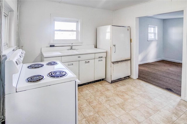 kitchen with white appliances, light carpet, white cabinetry, and sink