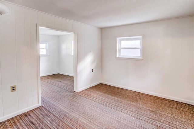 empty room with a healthy amount of sunlight and carpet floors