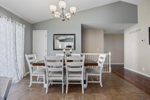 dining area featuring lofted ceiling, dark hardwood / wood-style floors, and a chandelier