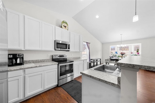 kitchen with white cabinetry, stainless steel appliances, sink, dark wood-type flooring, and pendant lighting