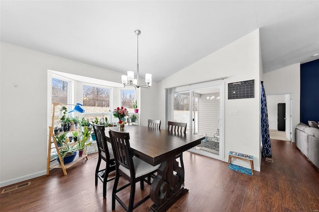 dining space with an inviting chandelier, dark wood-type flooring, and vaulted ceiling