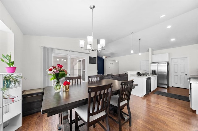 dining room featuring hardwood / wood-style flooring, a chandelier, and vaulted ceiling