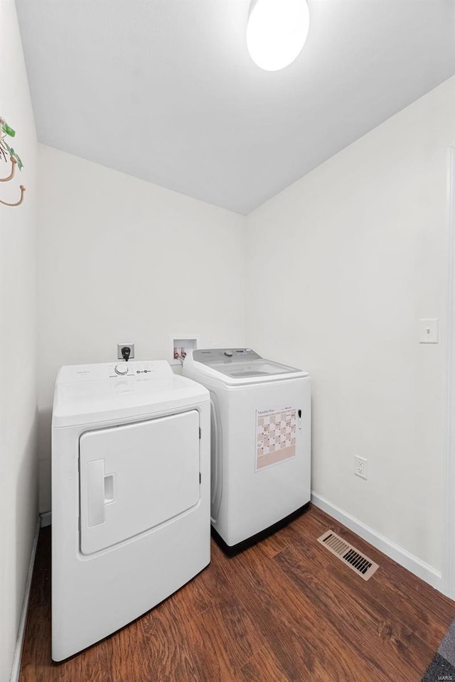 laundry room with dark hardwood / wood-style floors and washing machine and clothes dryer