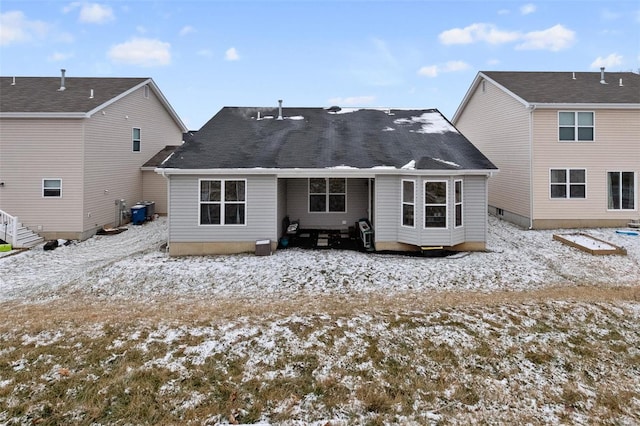 snow covered house featuring central air condition unit