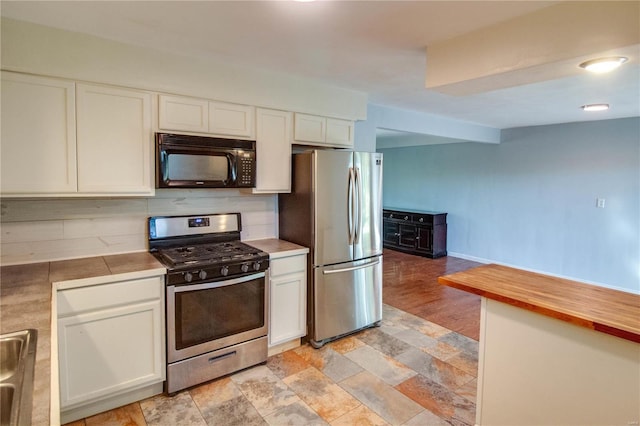 kitchen with tasteful backsplash, light wood-type flooring, butcher block counters, white cabinetry, and stainless steel appliances