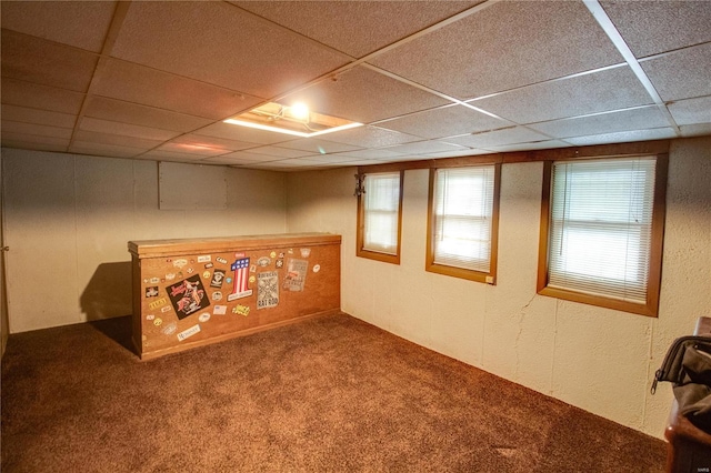 basement with a drop ceiling and carpet