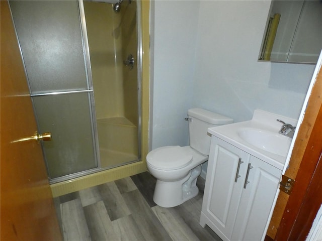 bathroom with walk in shower, wood-type flooring, vanity, and toilet