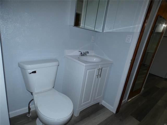 bathroom featuring hardwood / wood-style flooring, vanity, and toilet