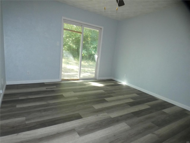 empty room with dark hardwood / wood-style floors and ceiling fan