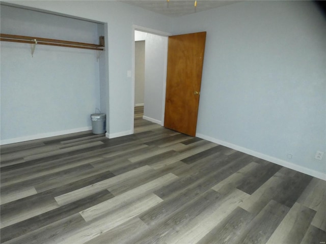 unfurnished bedroom featuring a closet and dark hardwood / wood-style floors