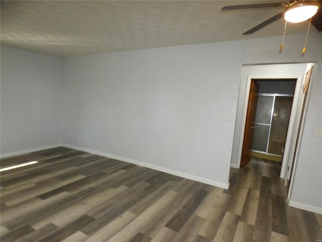 unfurnished room with dark hardwood / wood-style flooring and ceiling fan