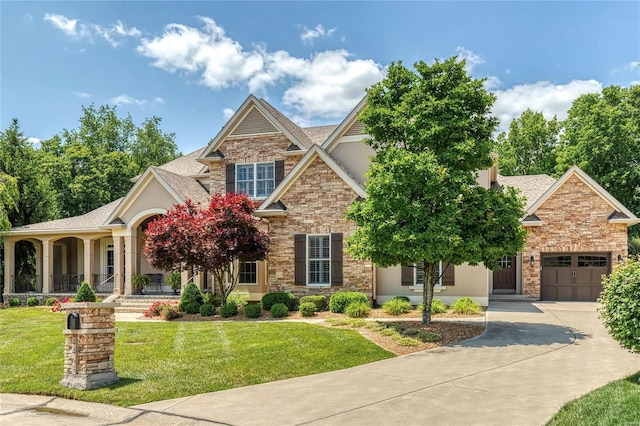 craftsman-style home featuring a front yard, a garage, stone siding, and a shingled roof