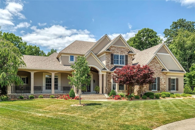 craftsman inspired home with stone siding, stucco siding, a front yard, and roof with shingles