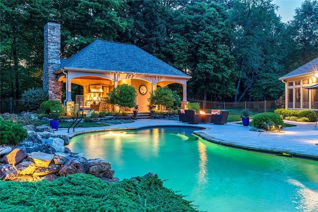 view of swimming pool featuring a fenced in pool, fence, an exterior structure, an outdoor structure, and a patio area