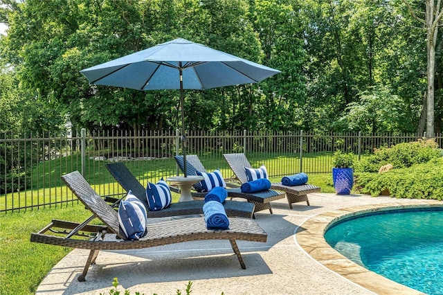 view of swimming pool featuring a patio area, a yard, fence, and a fenced in pool