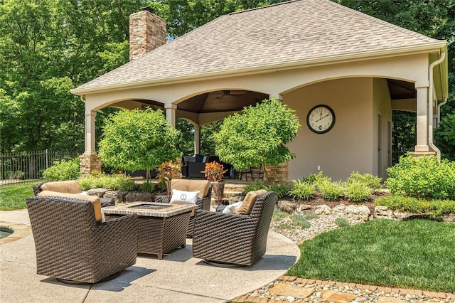 view of patio / terrace with an outdoor living space with a fire pit, a ceiling fan, and fence