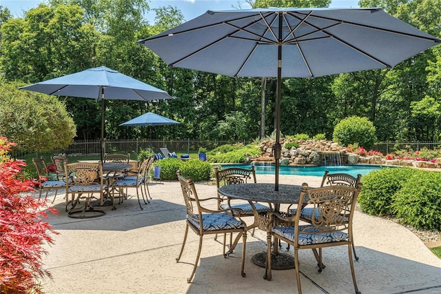 view of patio featuring outdoor dining space, fence, and a fenced in pool