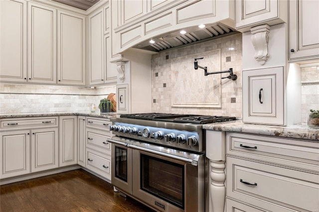 kitchen featuring range with two ovens, tasteful backsplash, premium range hood, and dark wood-style flooring