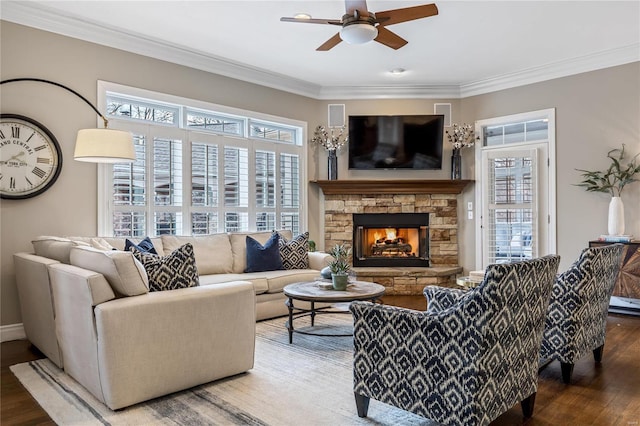 living area with wood finished floors, a healthy amount of sunlight, ceiling fan, and ornamental molding