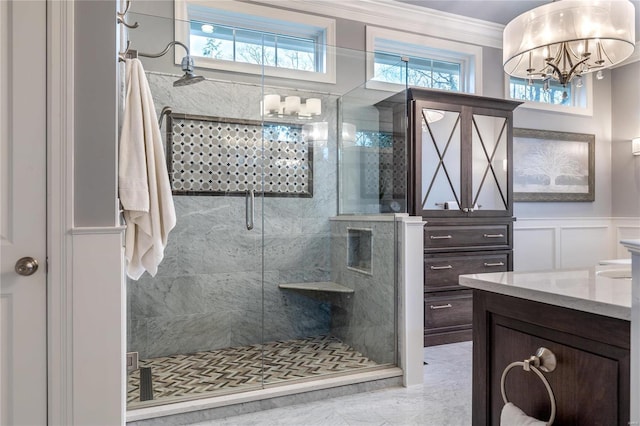 full bathroom with plenty of natural light, a stall shower, crown molding, a decorative wall, and a notable chandelier